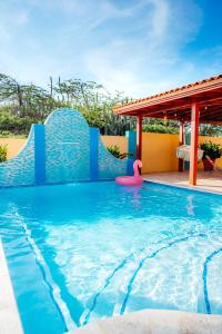 a swimming pool with a slide in a house at Villa Encantada Aruba in Noord