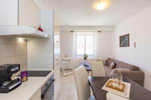 cocina y sala de estar con mesa en Apartmani Xenia & Desiderio, en Buzet
