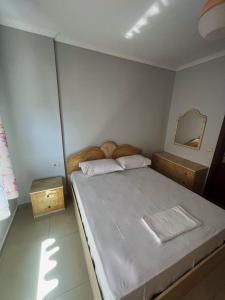 ein kleines Schlafzimmer mit einem Bett und einem Spiegel in der Unterkunft Silvi C&S in Fier