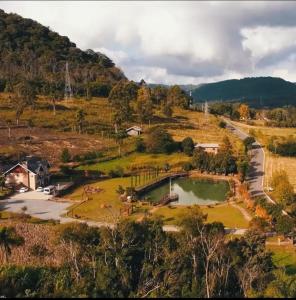 an aerial view of a farm with a pond at Palast Haus Pousada in Gramado