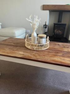 a coffee table with a vase and other items on it at Pretty Ground Cottage in Comrie in Comrie