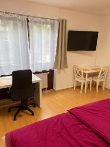 a bedroom with a desk and a table and a tableablish at Zimmer im Herzen von Durlach in Karlsruhe