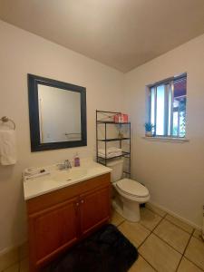 a bathroom with a sink and a toilet and a mirror at Wona's 2 bedrooms full kitchen in Oakhurst