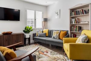 uma sala de estar com dois sofás e uma televisão em Pickle Pot Loft- 2 bedroom apartment in Hawkshead em Hawkshead