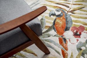 a parrot sitting on a chair in front of a rug at Pickle Pot Loft- 2 bedroom apartment in Hawkshead in Hawkshead