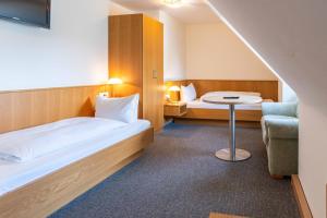 ein Hotelzimmer mit einem Bett und einem Stuhl in der Unterkunft Hotel am Römerplatz in Ulm