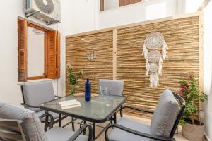 un patio con tavolo, sedie e parete in legno di La Costa Apartment Naxos a Naxos Chora