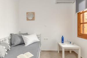 Camera bianca con letto e tavolo di La Costa Apartment Naxos a Naxos Chora
