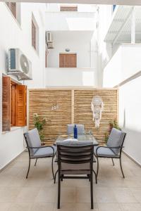 patio con tavolo, sedie e cranio appeso al muro di La Costa Apartment Naxos a Naxos Chora