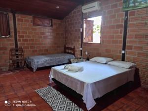 a bedroom with a bed and a brick wall at Cabana do Tapajós in Alter do Chao