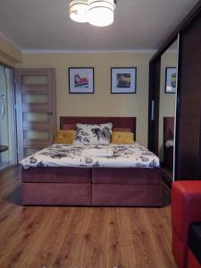 a bedroom with a bed with a wooden floor at Apartament Elegant in Katowice