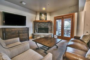 ein Wohnzimmer mit einem Tisch und einem Kamin in der Unterkunft Luxury Two Bedroom Suite with Hot Tub apartment hotel in Park City