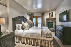 ein Schlafzimmer mit einem großen Bett und einem Kamin in der Unterkunft Luxury Two Bedroom Suite with Hot Tub apartment hotel in Park City