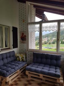 a living room with blue couches and a large window at Chalet Heidi in Serrada