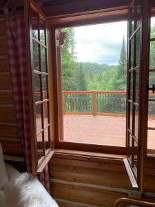a window in a room with a view of a deck at Family & Pets Friendly 6 Person Remote Work Mountain View Oasis in Lac-Superieur