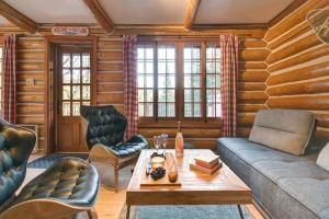 a living room with a couch and a table at Family Friendly Private Log Home 6 Person Remote Work Breathtaking Mountain Views Versant Nord in Lac-Superieur