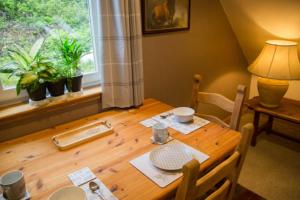 een houten tafel in een eetkamer met een raam bij Riverside Loft in Barcaldine