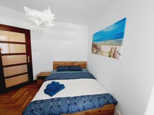 a bedroom with two beds and a picture on the wall at Apartament 15 min od morza in Gdańsk