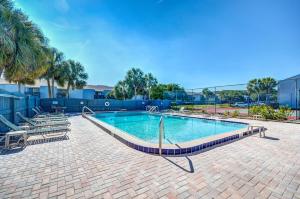 a swimming pool in a courtyard with palm trees at Walk to Beach-Fernandina Shores 6513-Pool & Tennis-On North End Near Main Beach in Fernandina Beach