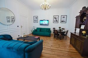 a living room with a blue couch and a table at Wilhelmstadt Apartment 60m - PARKING in Toruń
