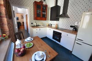 cocina con armarios blancos y mesa de madera en Wilhelmstadt Apartment 60m - PARKING, en Toruń