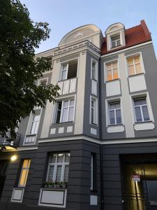 Un grand bâtiment blanc avec des fenêtres donne sur une rue. dans l'établissement Apartament Grunwaldzka, à Bydgoszcz