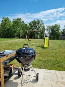 a grill and a playground in a park at Maison contemporaine au cœur de la Roche-Posay in La Roche-Posay