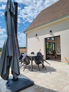 una sombrilla en un patio con sillas y mesa en Maison contemporaine au cœur de la Roche-Posay, en La Roche-Posay