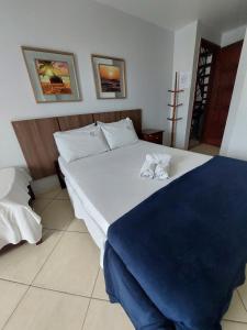 a bedroom with a large bed with two shoes on it at Pousada Fernandes in Arraial do Cabo