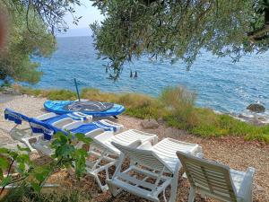 a table and chairs sitting next to the ocean at Villa nad Morem in Podaca
