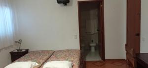 a bedroom with a bed and a bathroom with a toilet at Hotel Primavera in Monte Real