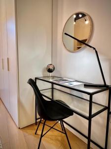 a glass desk with a black chair and a mirror at Art of living [Luxury House in Como] in Como