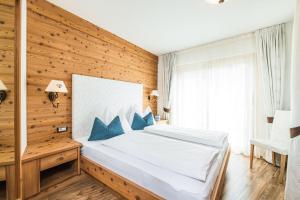セルヴァ・ディ・ヴァル・ガルデーナにあるAmonit - Your Dolomites Homeの木製の壁のベッドルーム1室(ベッド1台付)