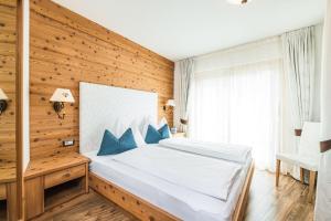 a bedroom with a bed and a wooden wall at Amonit - Your Dolomites Home in Selva di Val Gardena