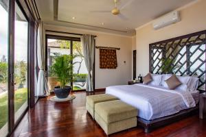 sypialnia z dużym łóżkiem i dużym oknem w obiekcie Nusa Dua Ocean Cliff Dream w mieście Ungasan