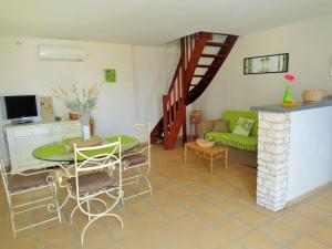 a living room with a green couch and a table at Le Cabanon in Farinole