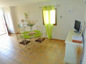 a living room with a table and a television at Le Cabanon in Farinole