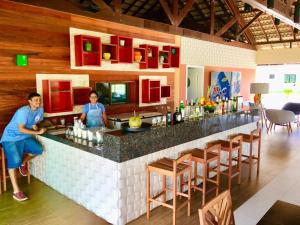 two women standing at a bar in a restaurant at Cumbuco - VGSun Apartment 402 in Cumbuco