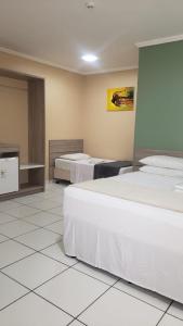 a hotel room with two beds in a room at Pratico Hotel in Santarém