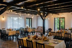 a banquet hall with tables and chairs and a couch at Agropensiunea Nemira in Dărmăneşti