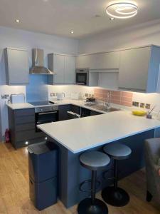 a large kitchen with a counter and stools in it at Sea View Apartment - Sleeps 2 in Aberystwyth