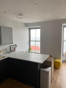 a kitchen with a black island in a room with windows at Sea View Apartment - Sleeps 2 in Aberystwyth