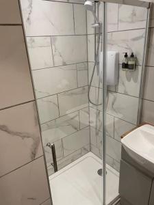 a shower with a glass door in a bathroom at Sea View Apartment - Sleeps 2 in Aberystwyth