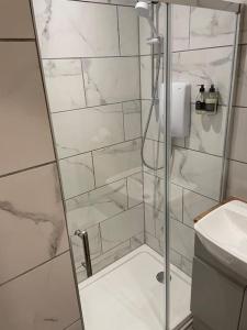 a shower with a glass door in a bathroom at Luxury Sea View Apartment - One Bedroom in Aberystwyth +42 photos