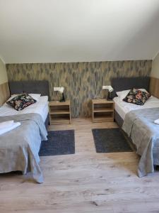 a room with two beds and two night stands at Leśniewo Czarna Góra in Leśniewo