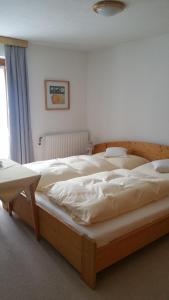 a bedroom with two beds with white sheets at Haus Walch in Pettneu am Arlberg