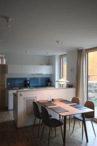 a kitchen with a wooden table and chairs in a room at An der Kirchtreppe in Blankenburg