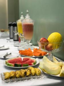 a table with plates of fruits and vegetables on it at Pratico Hotel in Santarém