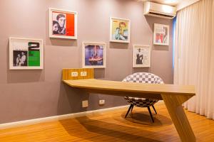 una mesa en una habitación con fotos en la pared en Lobie Queen Ipanema, en Río de Janeiro