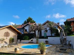 a house with a swimming pool in a yard at Chalés Valle Florido in Monte Verde